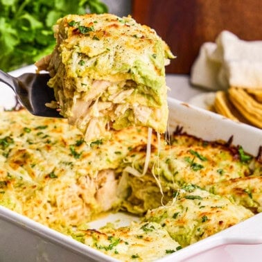 Creamy Chicken Enchilada Casserole being dished out with a spatula.