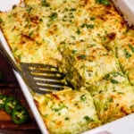 Creamy Chicken Enchilada Casserole being dished out with a spatula.