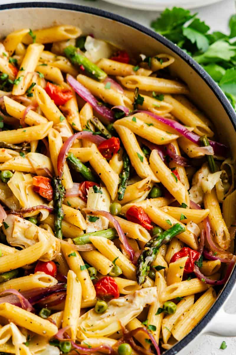Closeup of Creamy Pasta Primavera in a cast iron skillet.