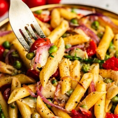 Closeup of Creamy Pasta Primavera on a plate with a fork bite.