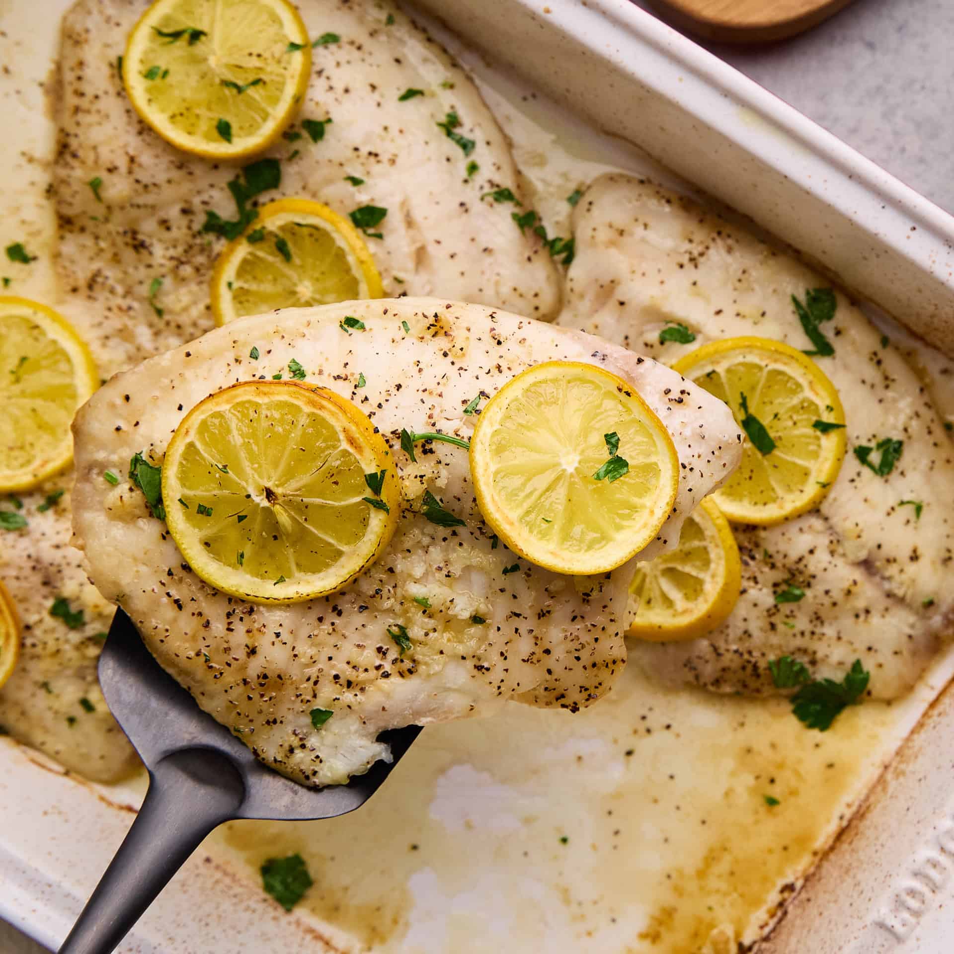 Easy Lemon Garlic Baked Tilapia on a spatula.