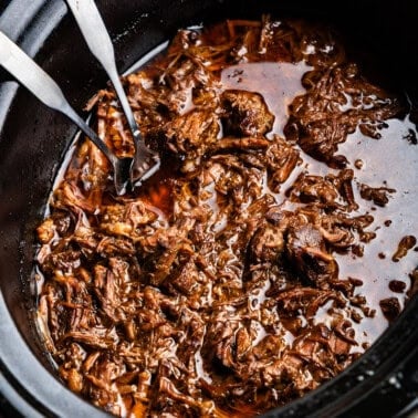 Closeup of Chili-Lime Mexican Shredded Beef in a slow cooker.