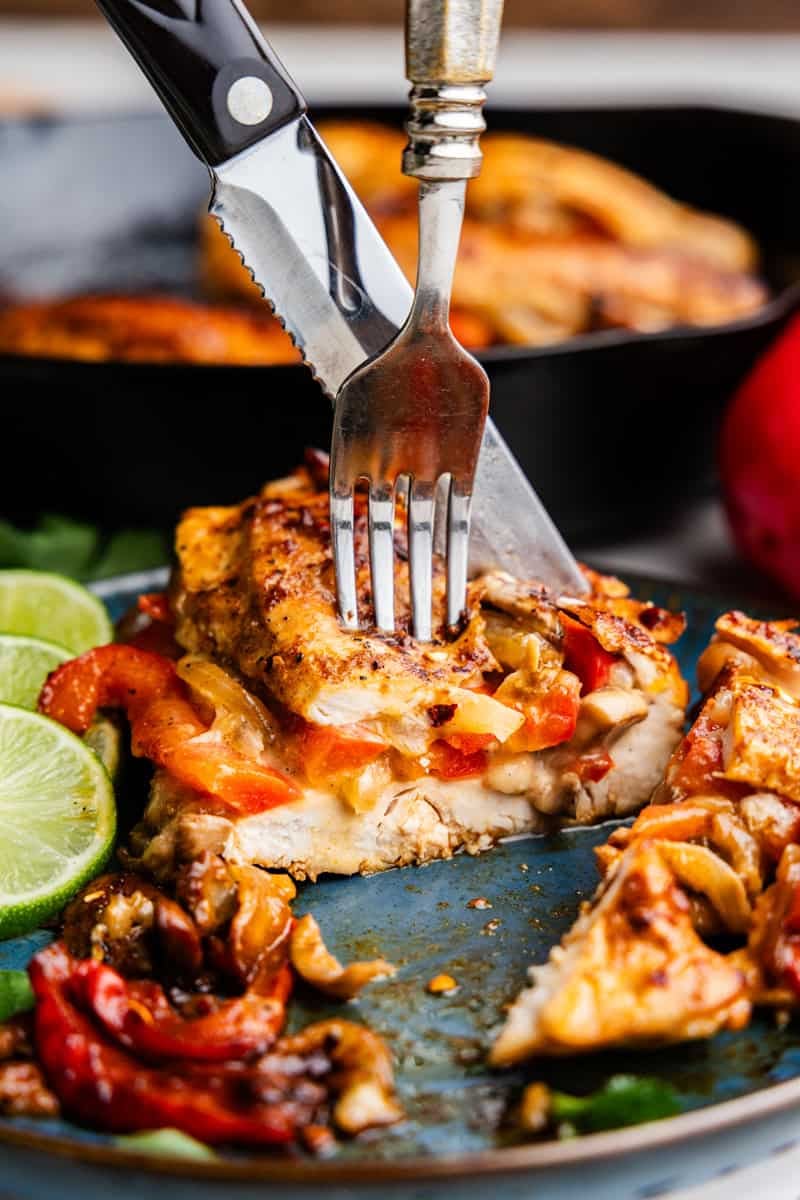 Closeup of Fajita Stuffed Chicken being cut on a plate.