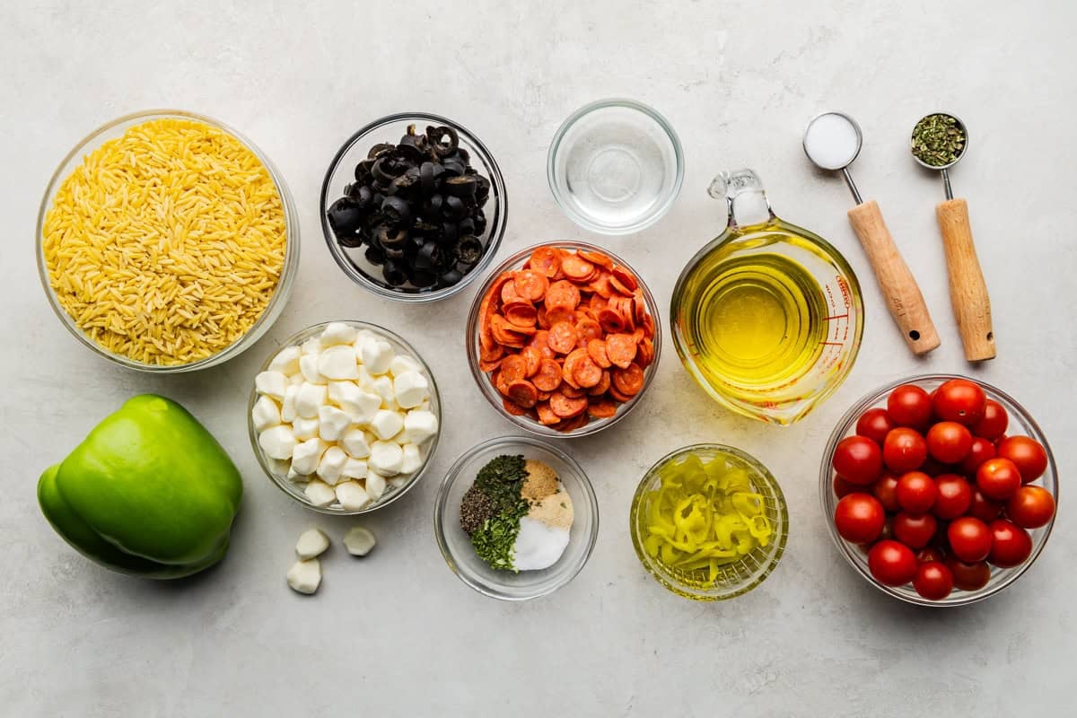 Los ingredientes utilizados para hacer ensalada de pasta orzo italiana.
