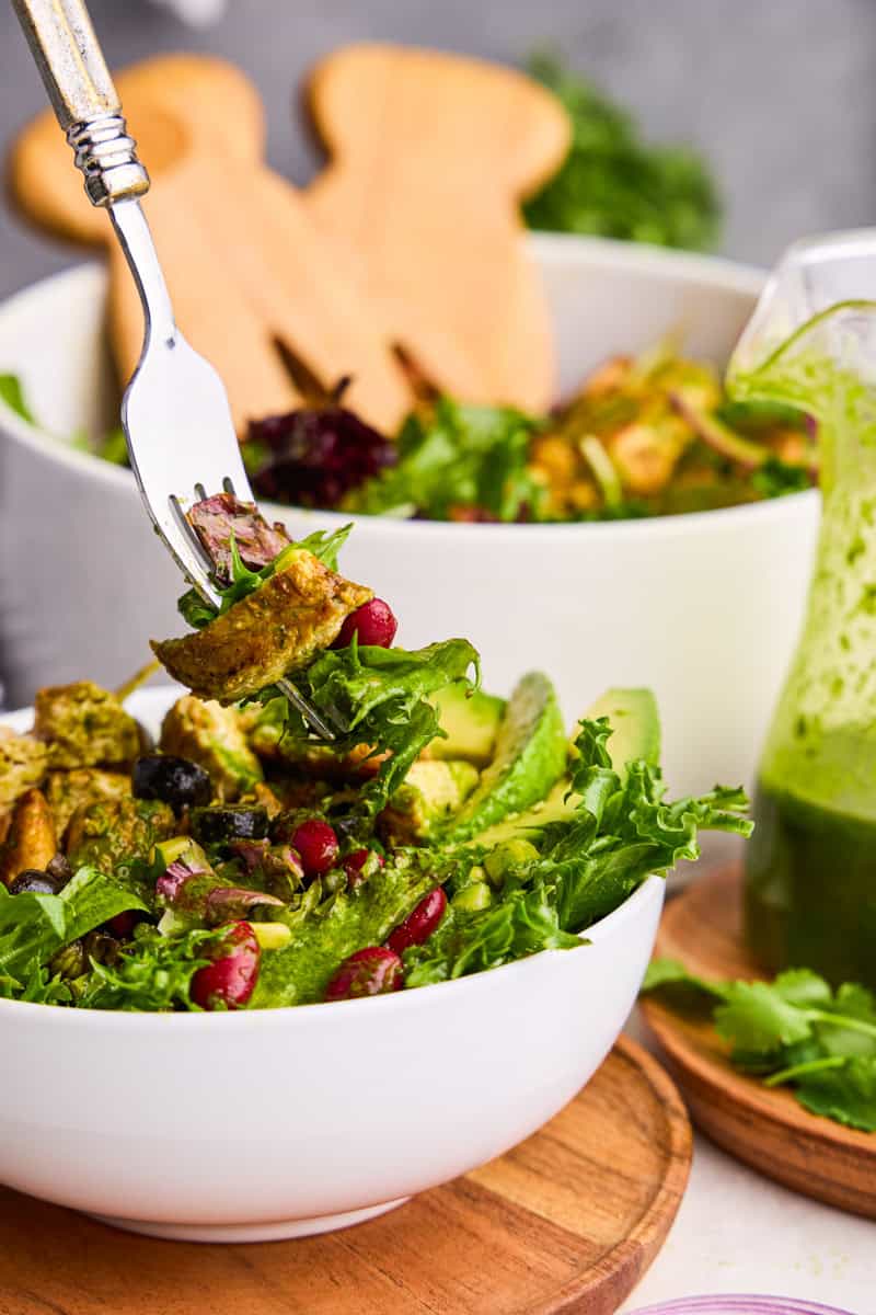 A forkful of Chicken Taco Salad with Cilantro-Lime Vinaigrette hovering over a bowl of salad.
