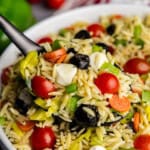 Italian orzo Pasta salad scooped up onto a serving spoon.