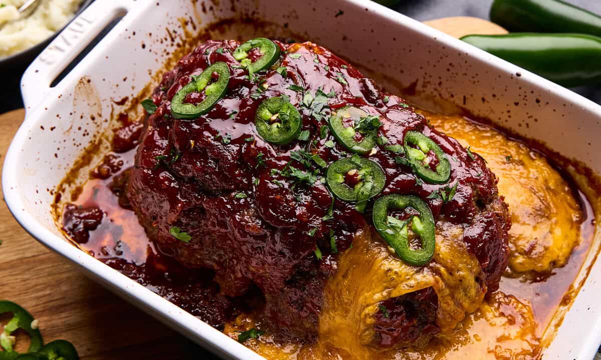 Overhead shot of Jalapeno Cheddar Stuffed Meatloaf in a roasting pan with ingredients surrounding it.