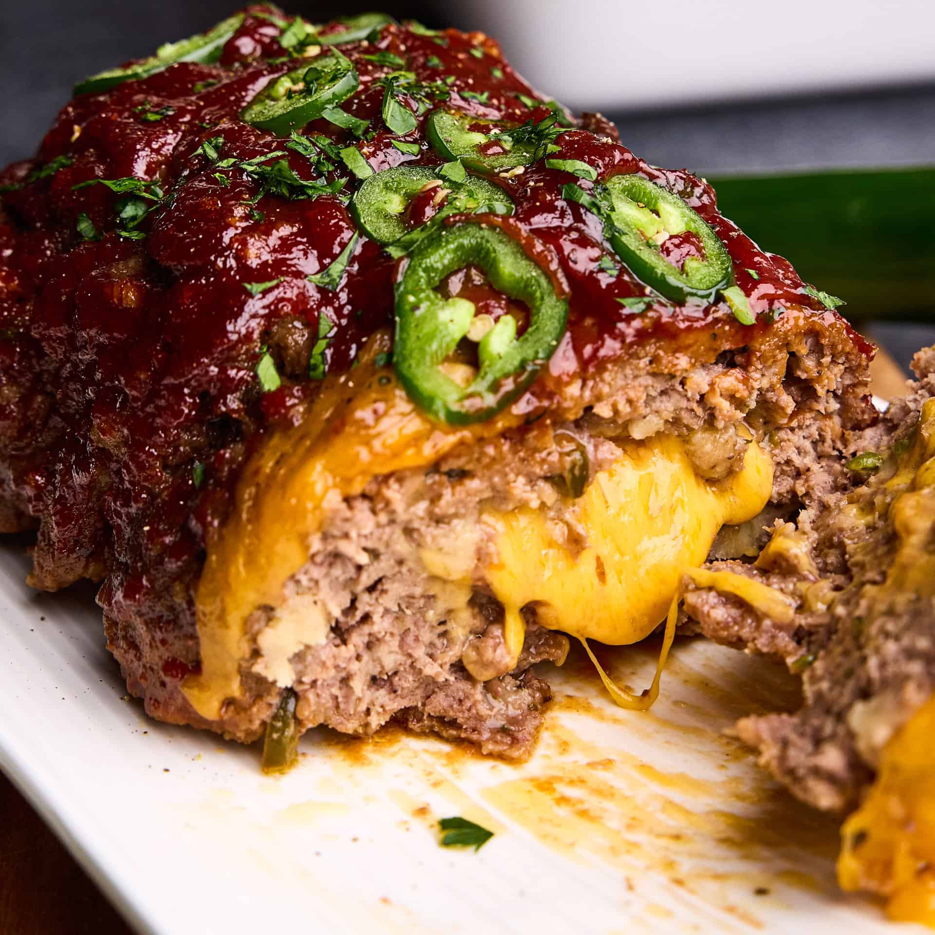 Closeup of cheese oozing out of Jalapeno Cheddar Stuffed Meatloaf.