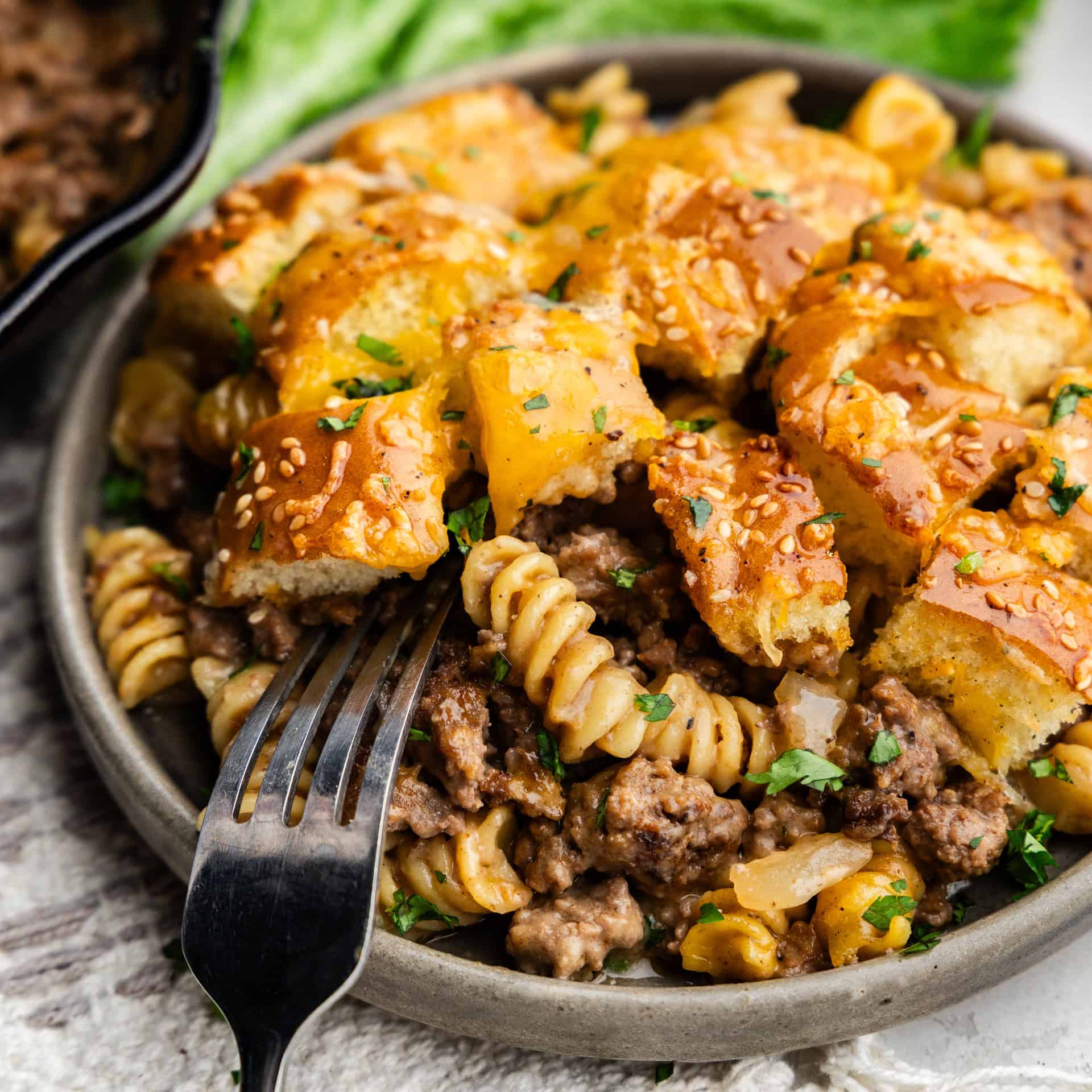 Closeup of cheeseburger casserole on a plate with a fork.