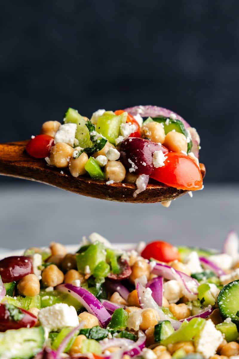 Closeup of a spoonful of Chickpea salad over a bowl.