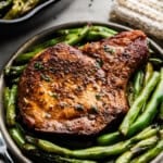 Closeup of Garlic Butter Pork Chops and green beans on a plate.