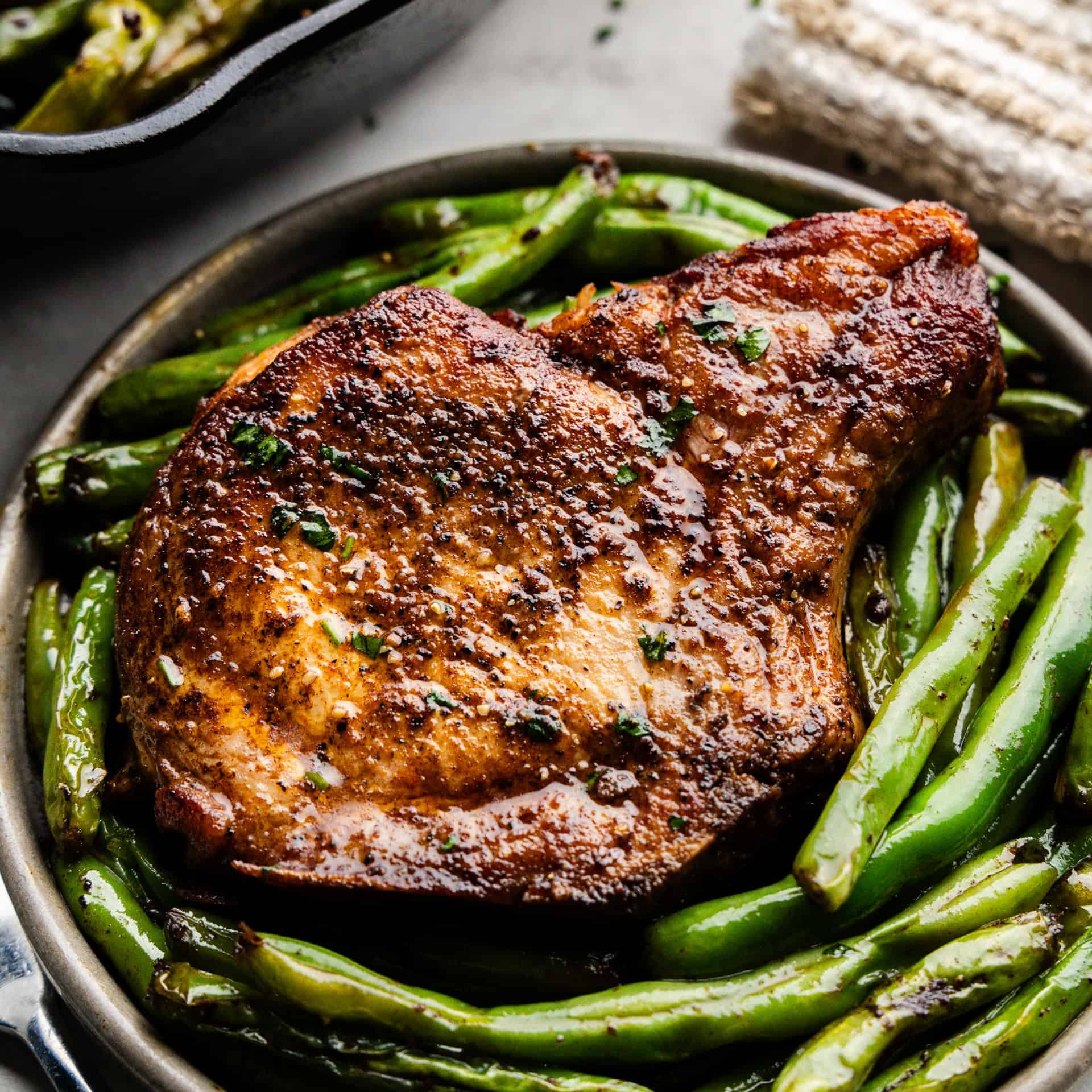 Closeup of Garlic Butter Pork Chops and green beans on a plate.