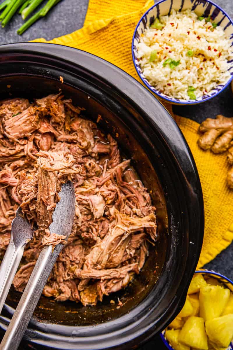Slow Cooker Kalua Pork with ingredients surrounding.