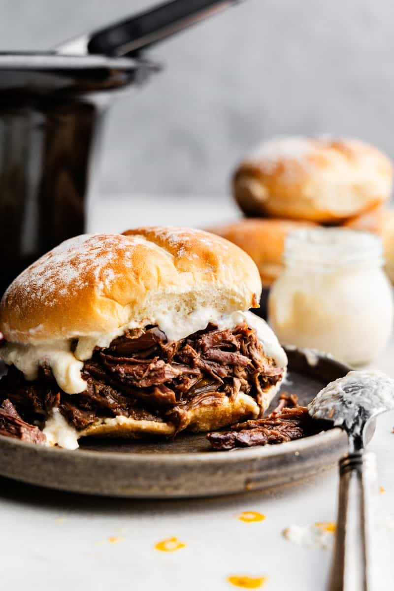 Primer plano de un sándwich de carne y rábano picante rallado en un plato.