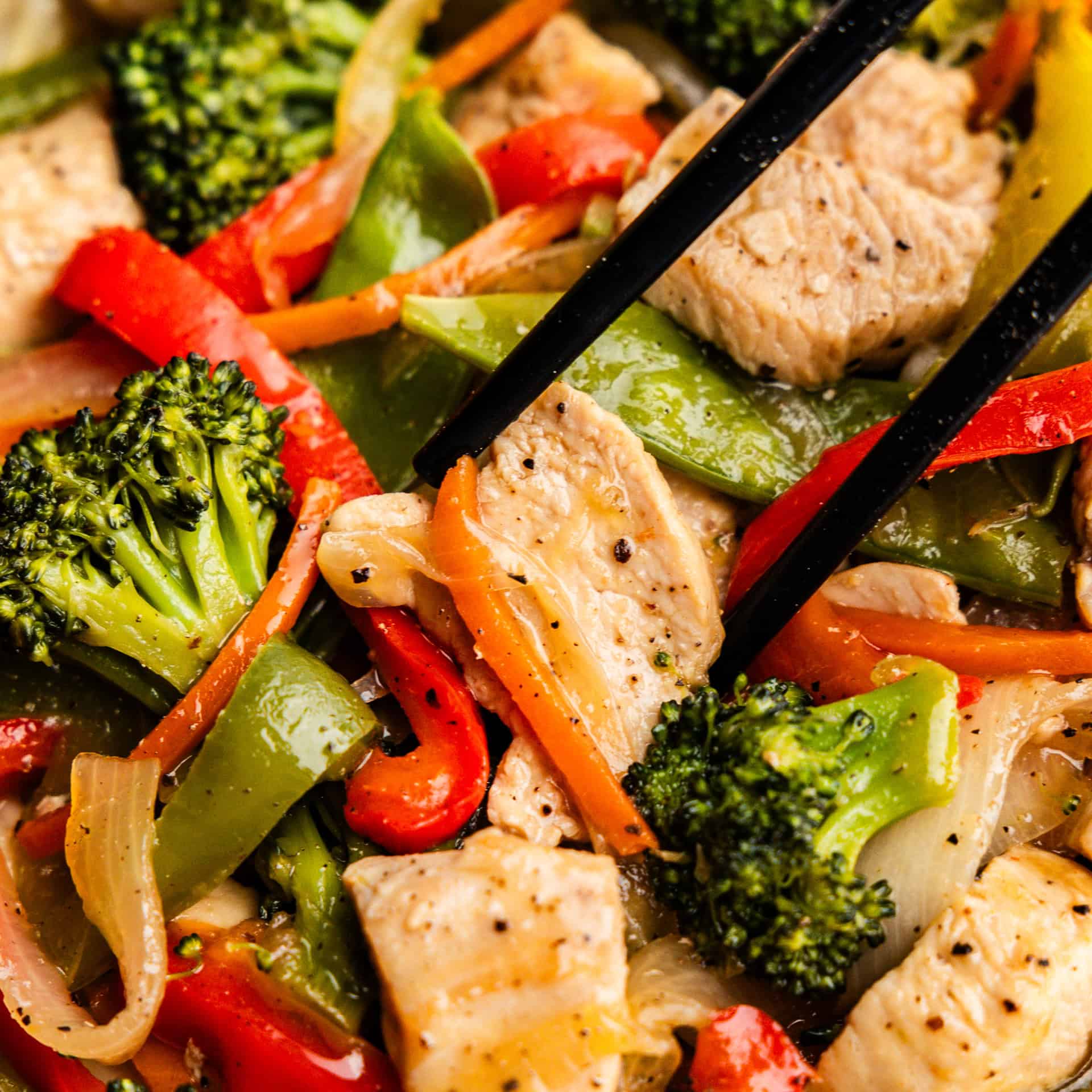 Closeup of Take-Out Chicken Stir Fry being held by chopsticks.