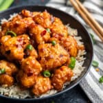 Closeup of General Tso Chicken on a plate of rice.