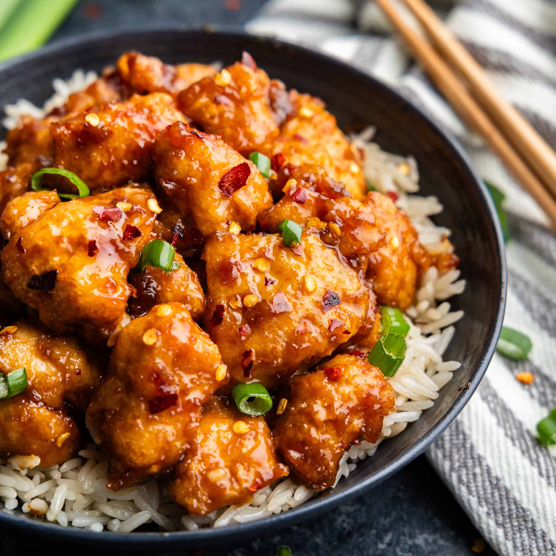 Closeup of General Tso Chicken on a plate of rice.