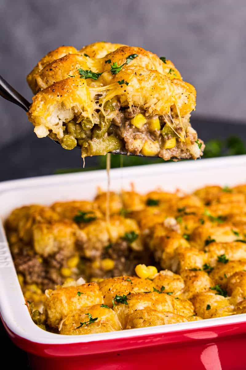 A piece of Tasty Tater Tot Casserole being dished out of pan.