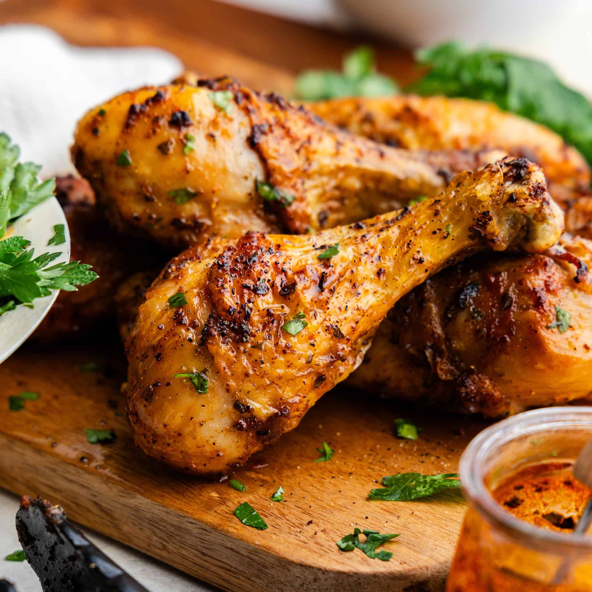 Closeup of chicken legs piled on a wooden board.