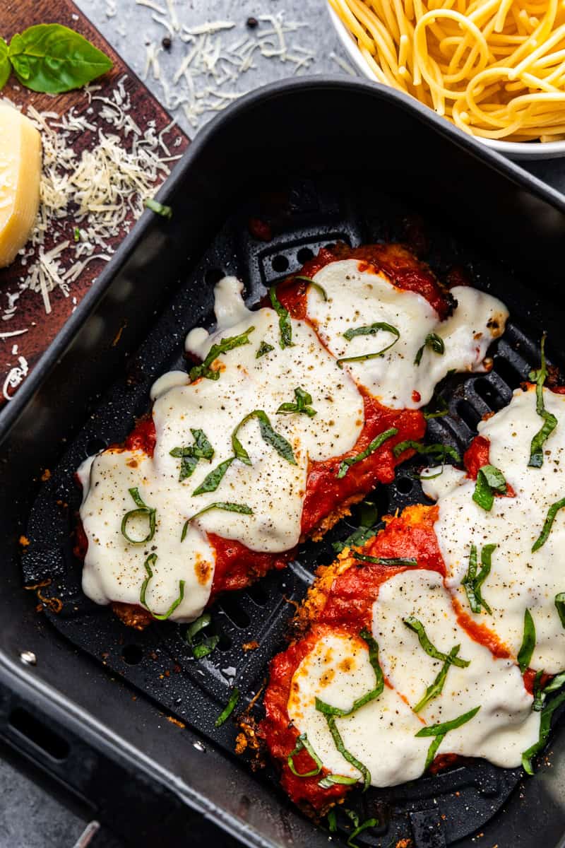 Overhead closeup of chicken parmesan in an air fryer.
