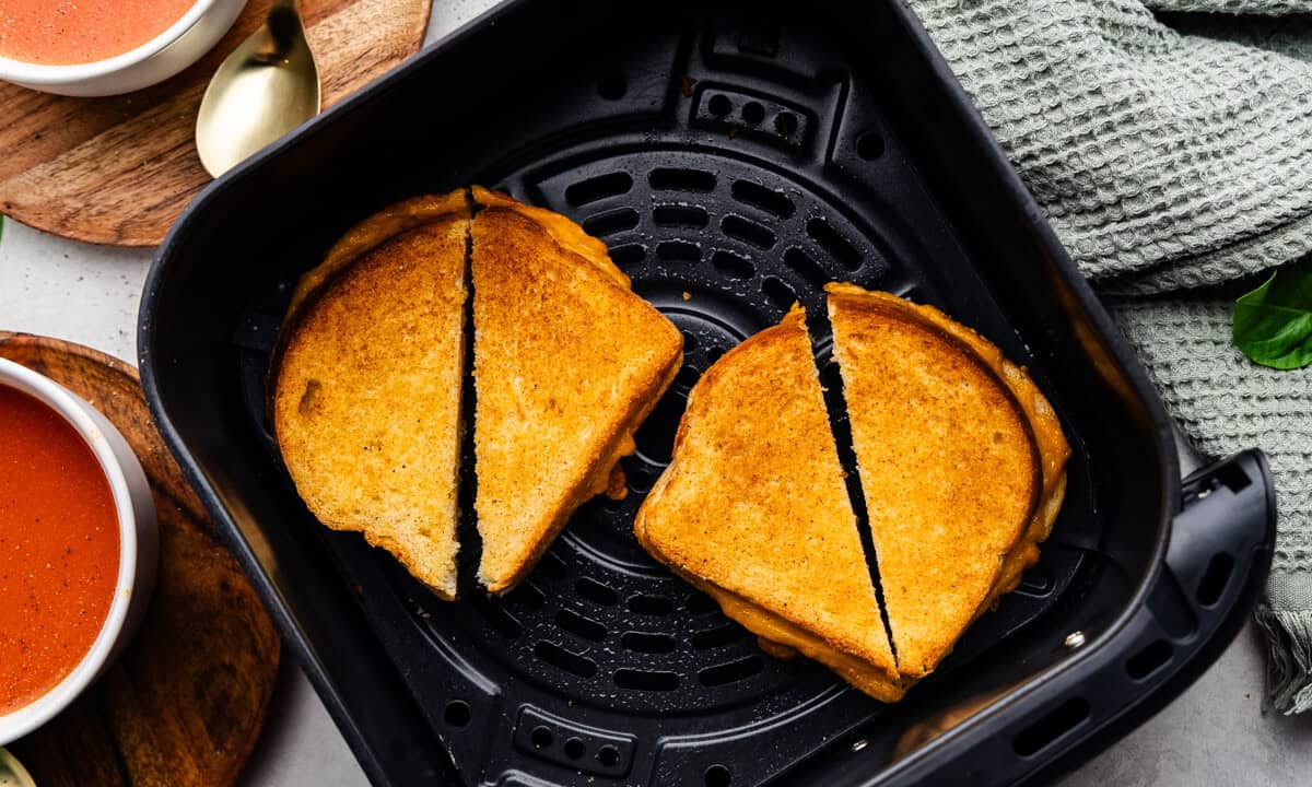 Closeup of two Grilled cheese sandwiches split in half in the air fryer.