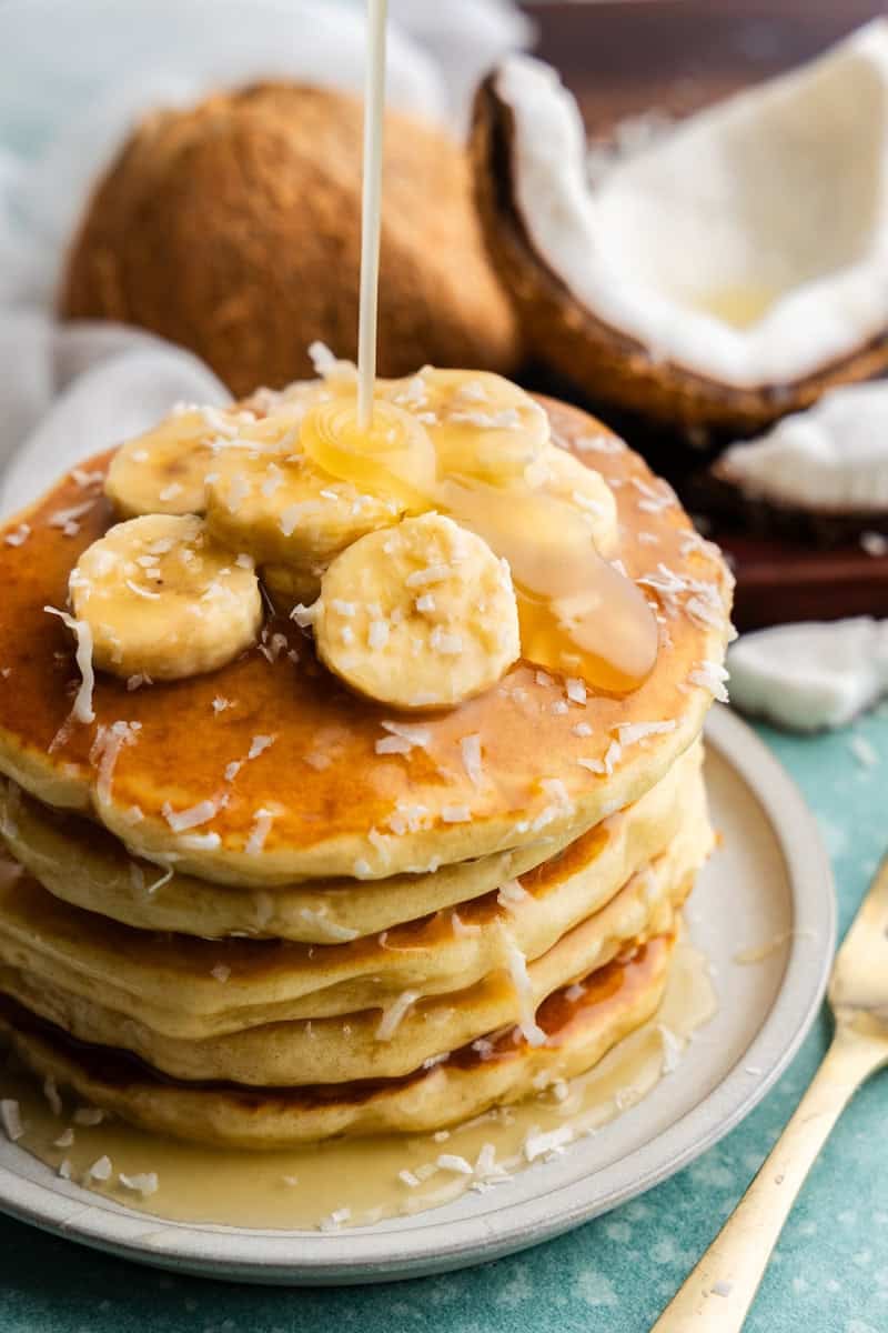 Coconut Syrup being poured on pancakes.