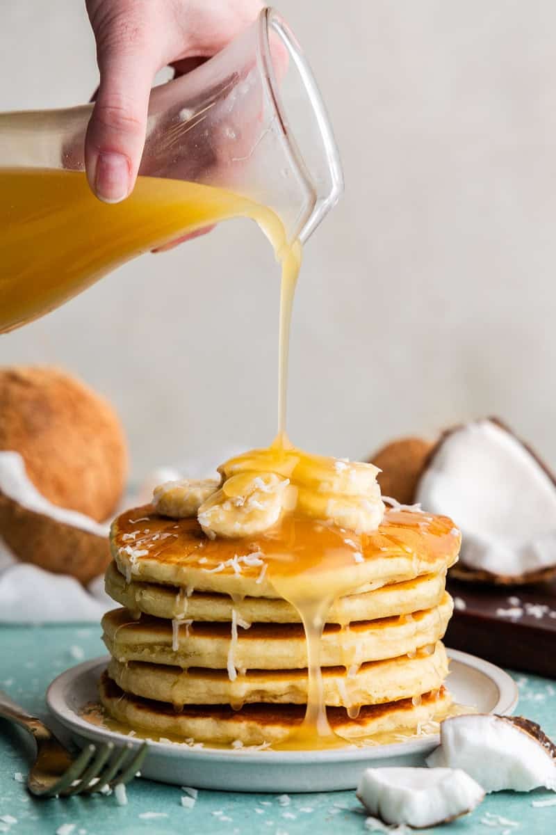 Coconut Syrup being poured on pancakes.