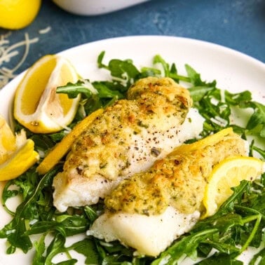 Easy Lemon Baked Cod Fish on a plate with lemons.