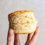 Closeup of hand holding a flaky biscuit.