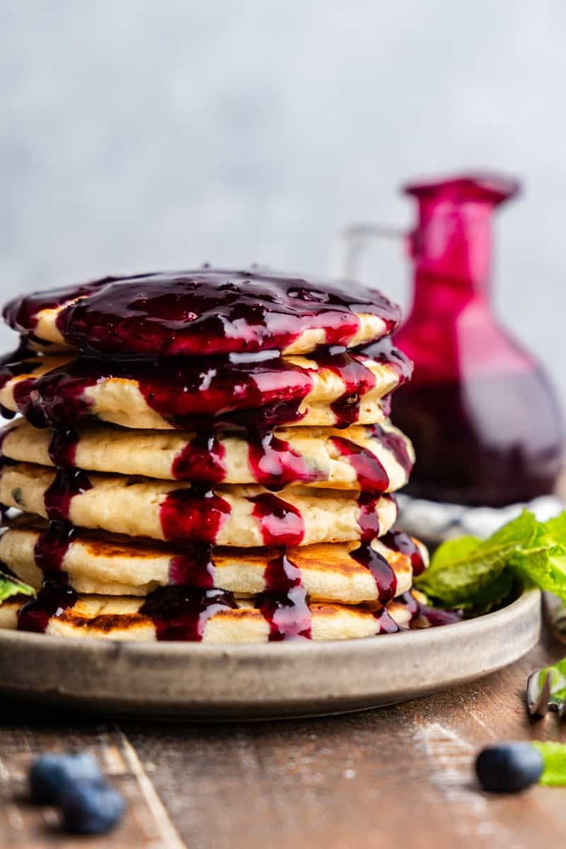 Closeup of blueberry syrup covering pancakes.