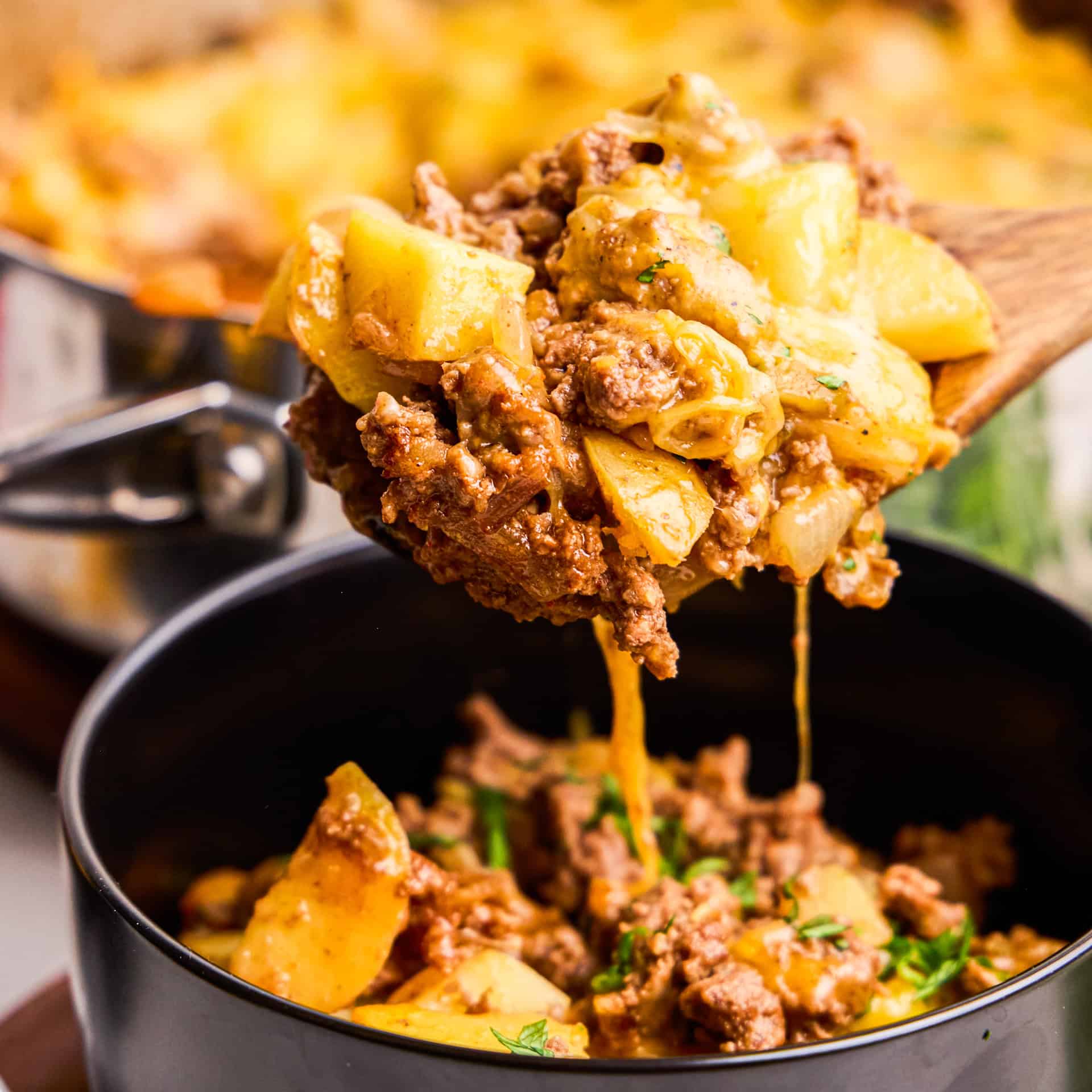 A wooden spoonful cheesy One Pot American Picadillo.