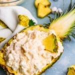 Overhead image of Pineapple Fluff in a hollowed out pineapple with ingredients around it.
