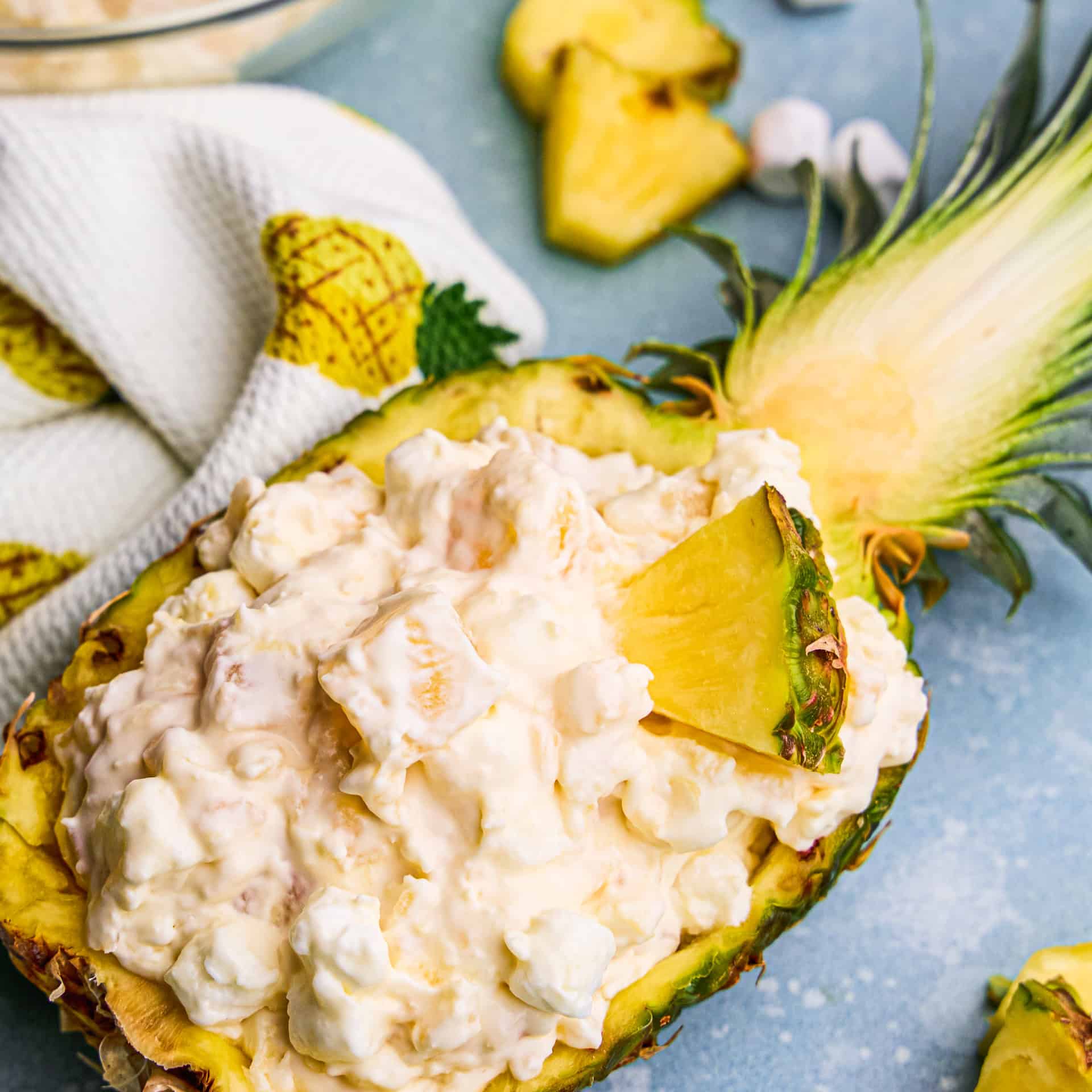 Overhead image of Pineapple Fluff in a hollowed out pineapple with ingredients around it.