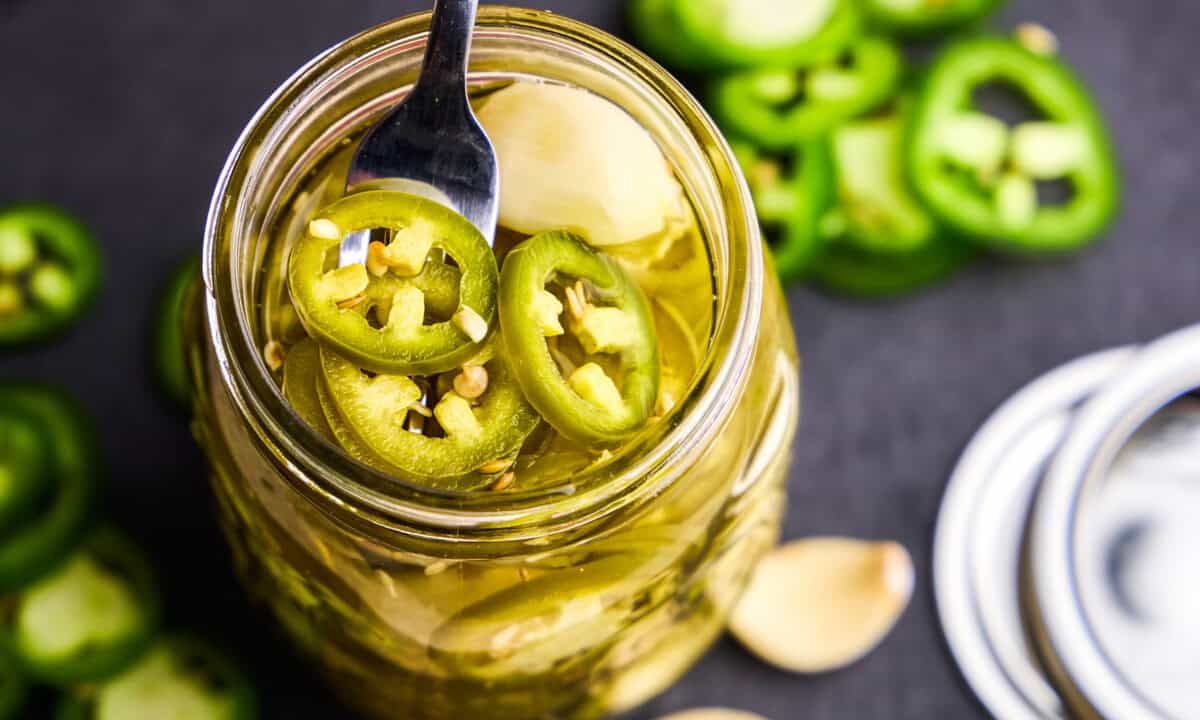 Overhead image of Quick Pickled Jalapeños in a glass jar.
