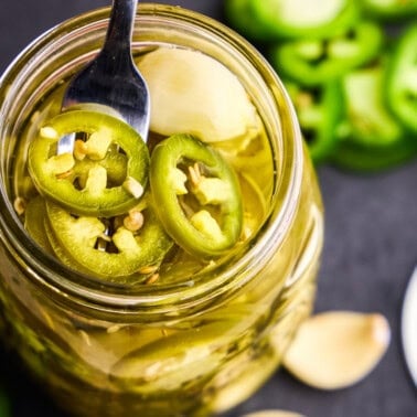Overhead image of Quick Pickled Jalapeños in a glass jar.