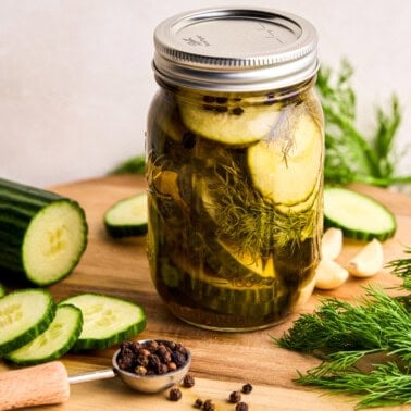 Refrigerator Pickles in a glass jar with cucumbers, dill, garlic and peppercorns.