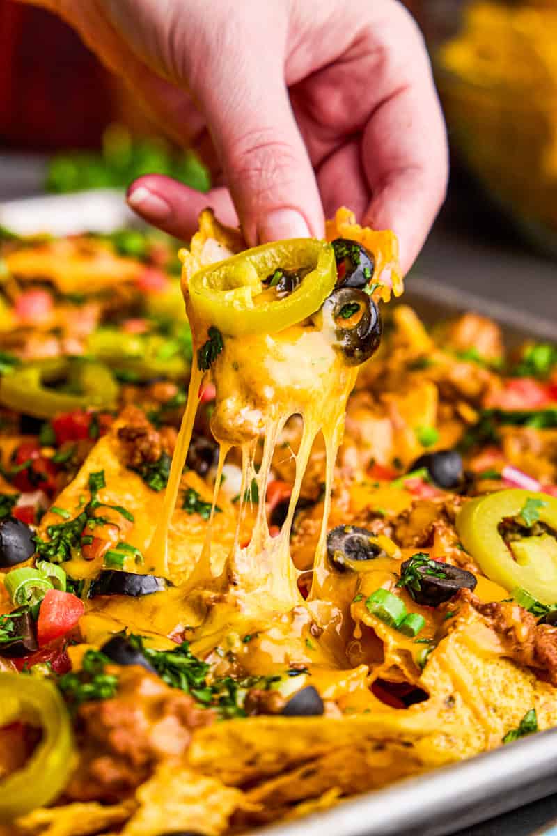 Ultimate Nacho Recipe chip with cheese pull.