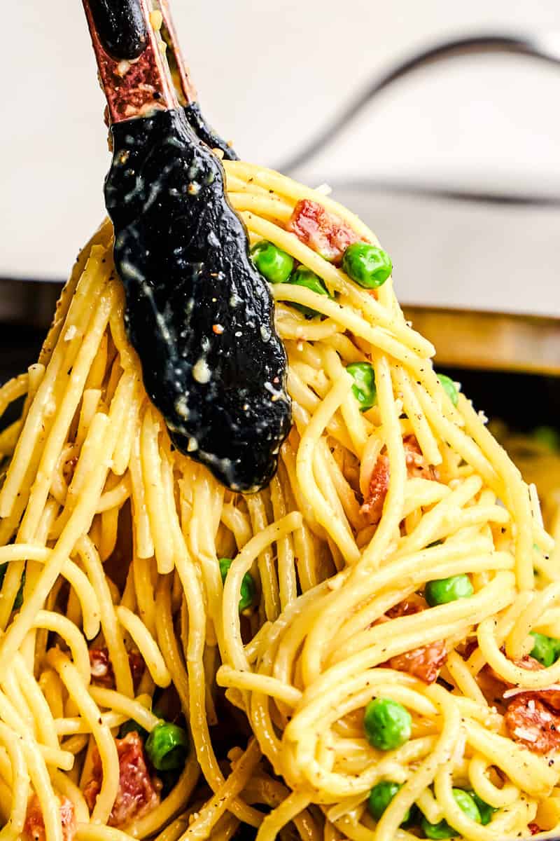 A pair of tongs serving up a American Carbonara.