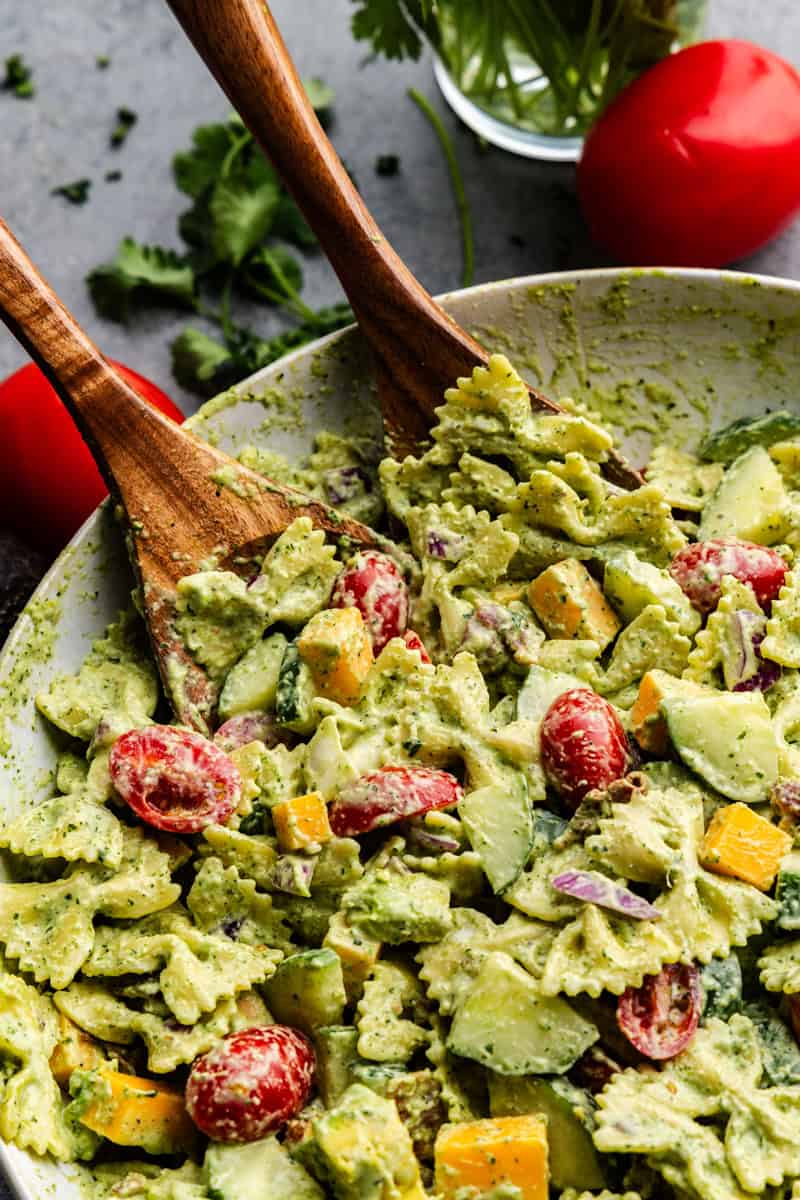 Closeup of cilantro ranch pasta salad being grabbed tongs.