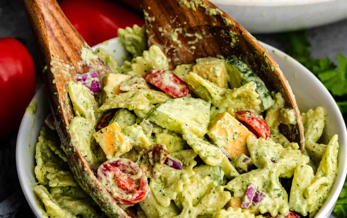 Closeup of cilantro ranch pasta salad being grabbed tongs.