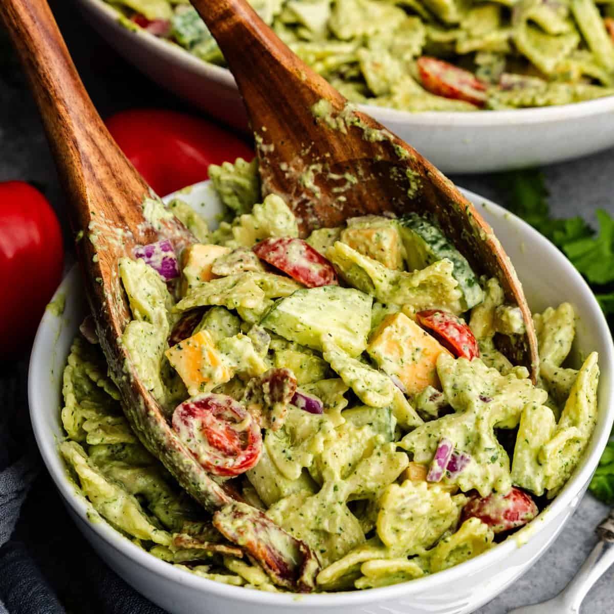 Closeup of cilantro ranch pasta salad being grabbed tongs.