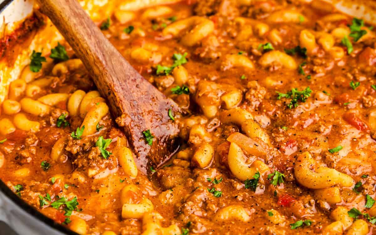 Old Fashioned American Goulash in a white cast iron pot.