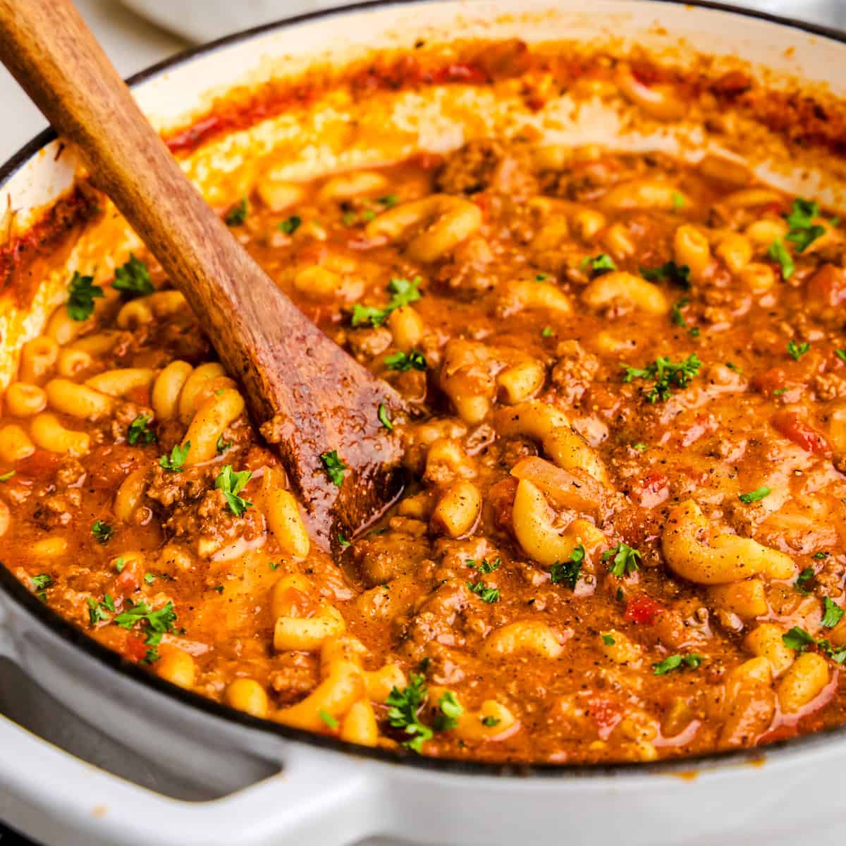 Old Fashioned American Goulash in a white cast iron pot.