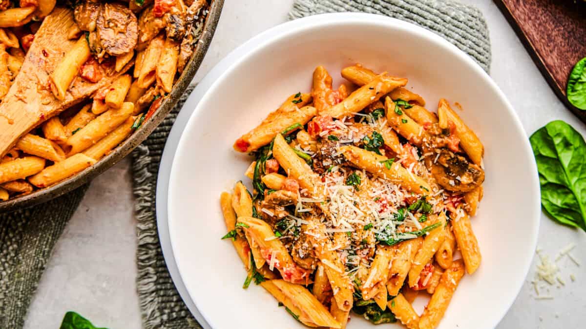 A bowl of Penne Rosa sprinkled with parmesan cheese.