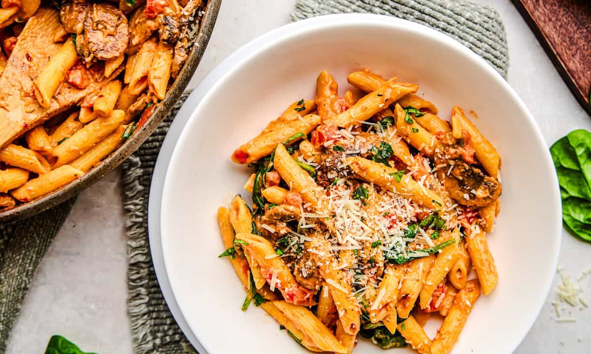 A bowl of Penne Rosa sprinkled with parmesan cheese.