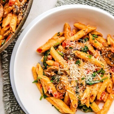 A bowl of Penne Rosa sprinkled with parmesan cheese.
