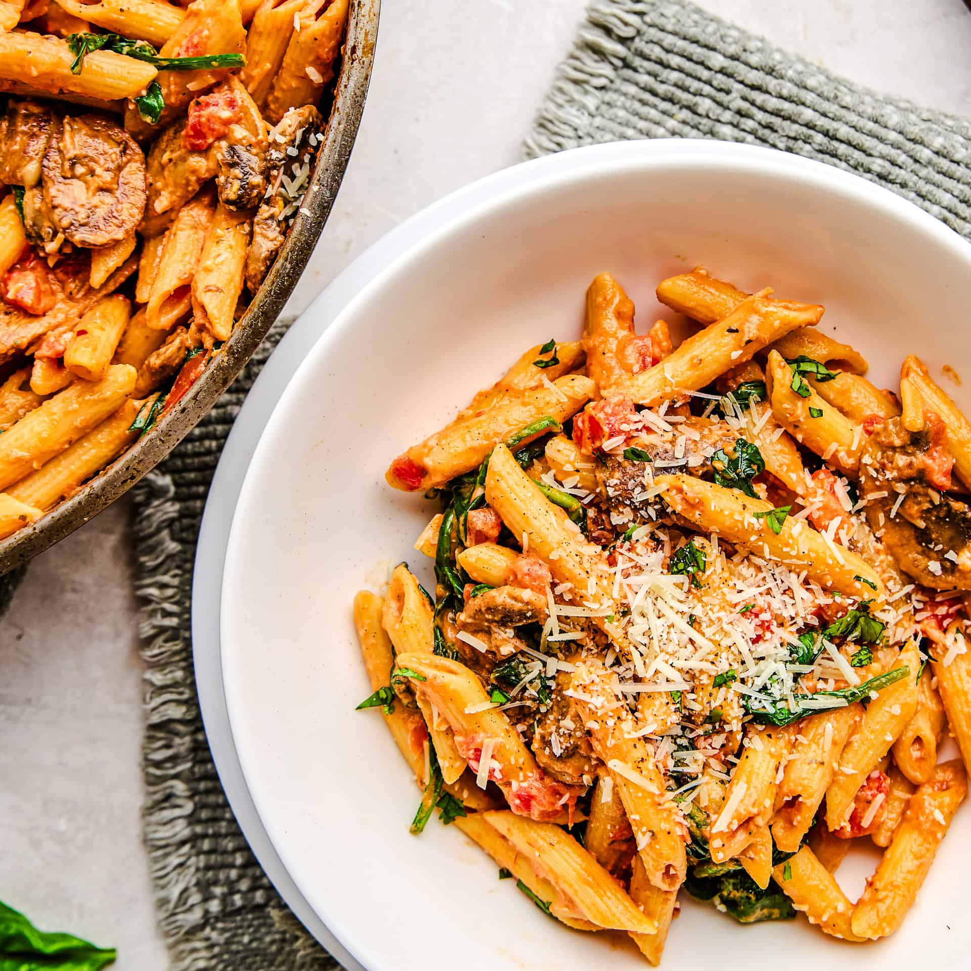 A bowl of Penne Rosa sprinkled with parmesan cheese.