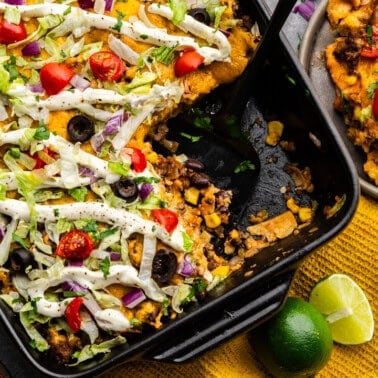 Overhead shot of Taco Casserole with scoop taken out and placed on a plate.