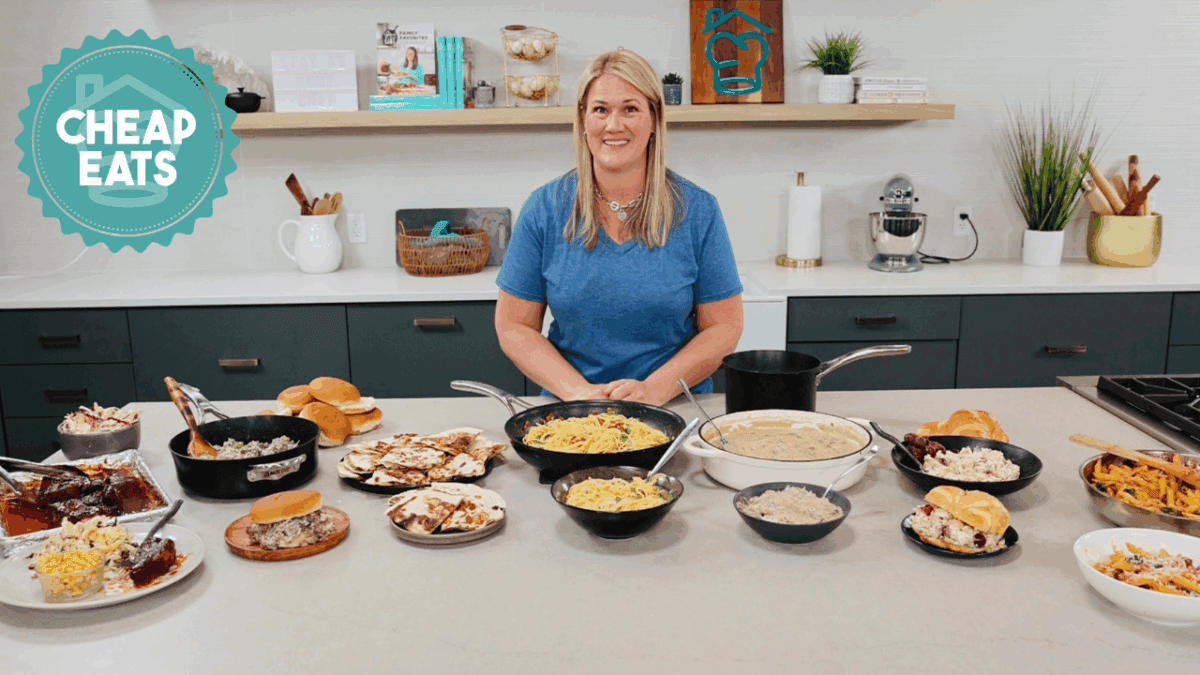 A photo of Chef Cayt in The Stay At Home Chef Kitchen with the meals from Week 1 of the Cheap Eats Meal plan on display on the kitchen counter.
