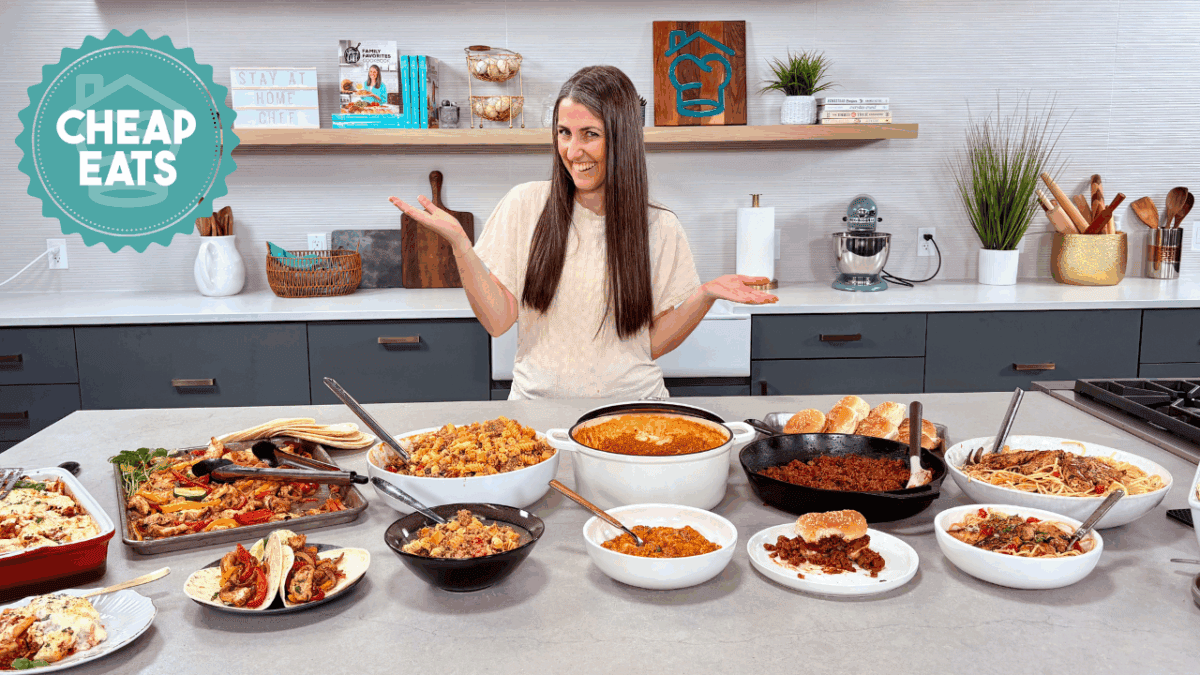 A photo of Rachel in The Stay At Home Chef Kitchen with the meals from Week 4 of the Cheap Eats Meal plan on display on the kitchen counter.